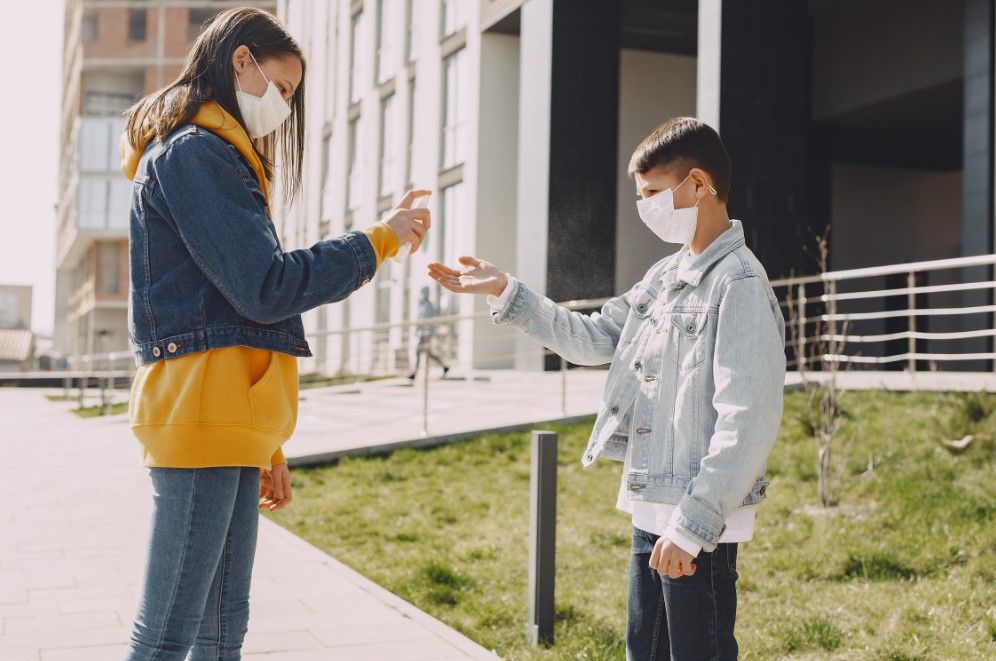 Enfants qui se désinfectent les mains avec du gel hydroalcoolique